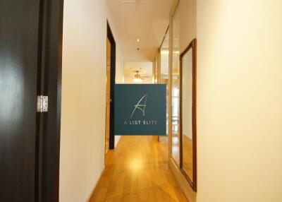 Well-lit hallway with wooden flooring and glass doors