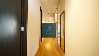 Well-lit hallway with wooden flooring and glass doors