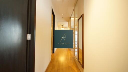 Well-lit hallway with wooden flooring and glass doors