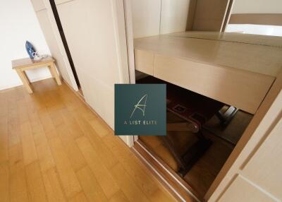 Bedroom with hardwood floor and small table with iron