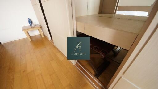 Bedroom with hardwood floor and small table with iron