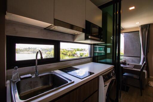 Modern kitchen with view, stove, sink, and appliances