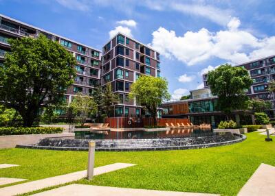 Modern apartment building with lush landscaping and water features