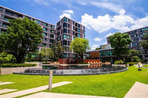 Modern apartment building with lush landscaping and water features