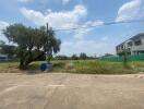 Empty lot with nearby buildings and a tree