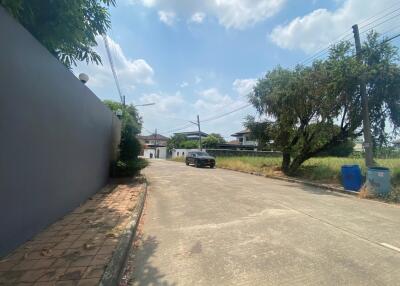 Gated community entrance with a clear sky and a car parked on the street