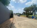 Gated community entrance with a clear sky and a car parked on the street