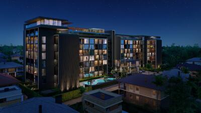 Modern residential building at night with illuminated windows and swimming pool