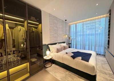 Modern bedroom with floor-to-ceiling windows, stylish decor, and a glass wardrobe