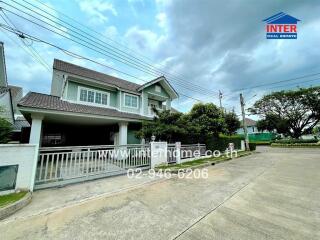 Two-story house with a driveway and gate