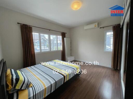 Spacious bedroom with large windows and a bed