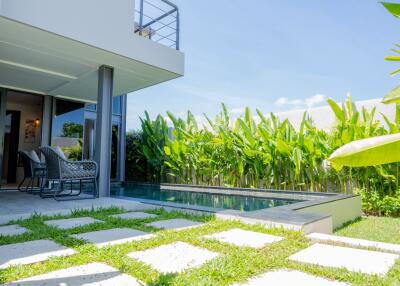 Modern outdoor patio with pool and greenery