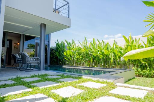 Modern outdoor patio with pool and greenery