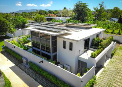 Aerial view of a modern building with solar panels and greenery