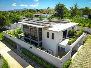 Aerial view of a modern building with solar panels and greenery