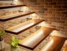 Modern wooden staircase with brick wall and plants