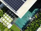 Aerial view of a pool with surrounding greenery and solar panels