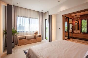 Spacious modern bedroom with large window and en-suite bathroom