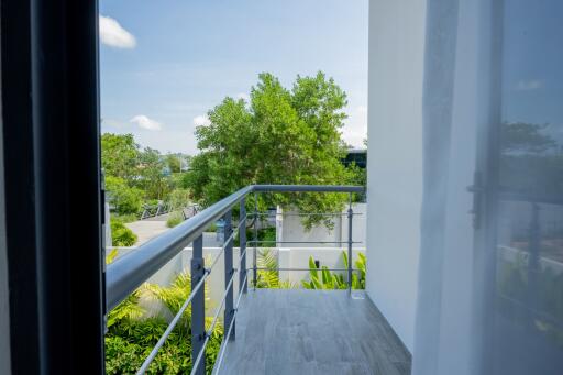 Small balcony with railing and a view of trees