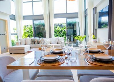 Modern dining and living area with large windows and natural lighting