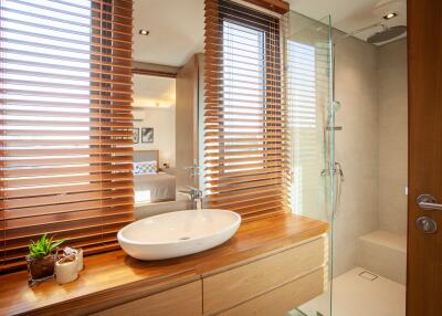 Modern bathroom with wooden blinds and walk-in shower