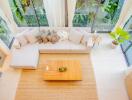 Top view of a modern living room with a large sectional sofa, coffee table, and large windows