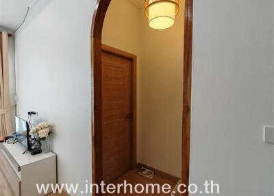 hallway with wooden door and arched entrance