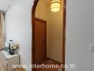 hallway with wooden door and arched entrance