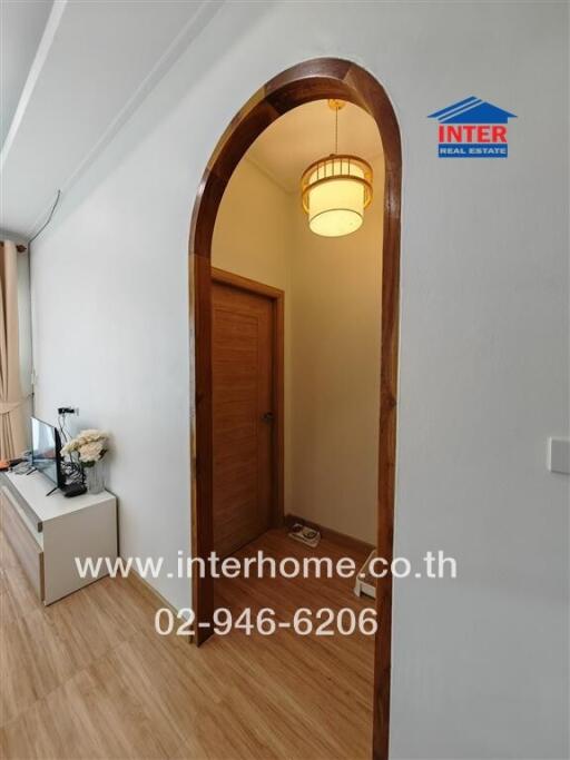 hallway with wooden door and arched entrance