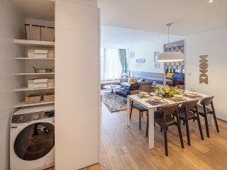 Modern open-concept dining and living area with laundry space