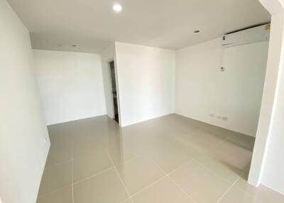 Spacious empty living room with tiled flooring and air conditioning unit