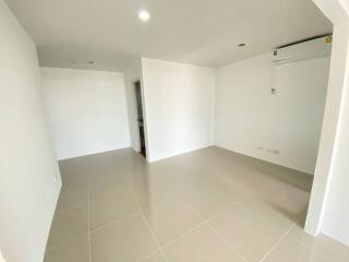 Spacious empty living room with tiled flooring and air conditioning unit