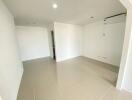 Spacious empty living room with tiled flooring and air conditioning unit