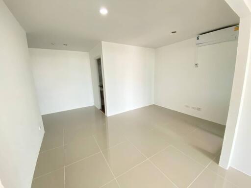 Spacious empty living room with tiled flooring and air conditioning unit