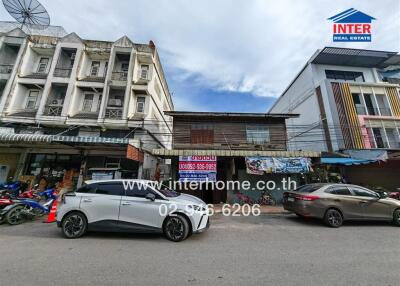 Facade of a commercial building with cars parked in front