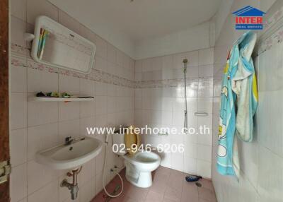 Bathroom with white tiles and a wall-mounted sink