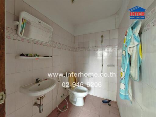 Bathroom with white tiles and a wall-mounted sink