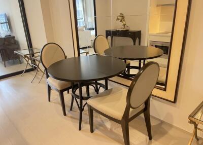 Modern dining area with round table, chairs, and large mirror