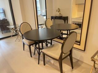 Modern dining area with round table, chairs, and large mirror