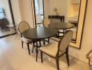 Modern dining area with round table, chairs, and large mirror