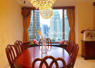 Dining room with wooden table and chairs, chandelier and view of city skyscrapers