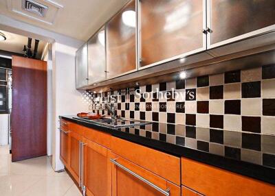 Modern kitchen with wooden cabinets, black countertop, and tiled backsplash