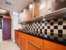 Modern kitchen with wooden cabinets, black countertop, and tiled backsplash