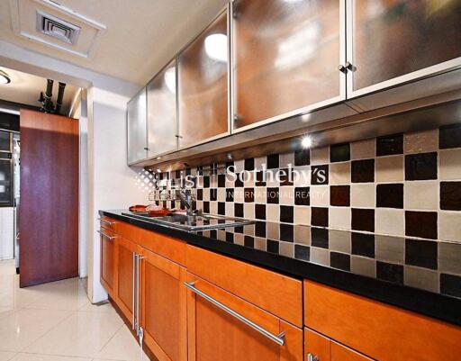 Modern kitchen with wooden cabinets, black countertop, and tiled backsplash