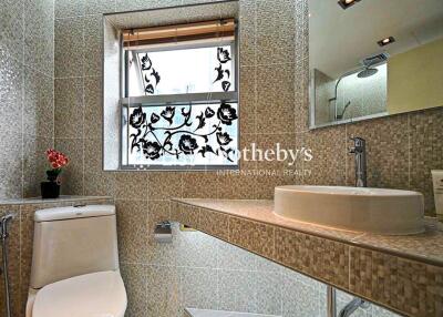 Modern bathroom with mosaic tiles and decorative window