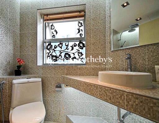 Modern bathroom with mosaic tiles and decorative window