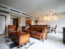 Living room with leather furniture and chandelier lighting