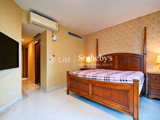 Spacious bedroom with wooden furniture and patterned wallpaper