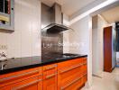 Modern kitchen with orange cabinets and black countertop