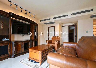 Spacious living room with leather furniture and large wooden entertainment unit